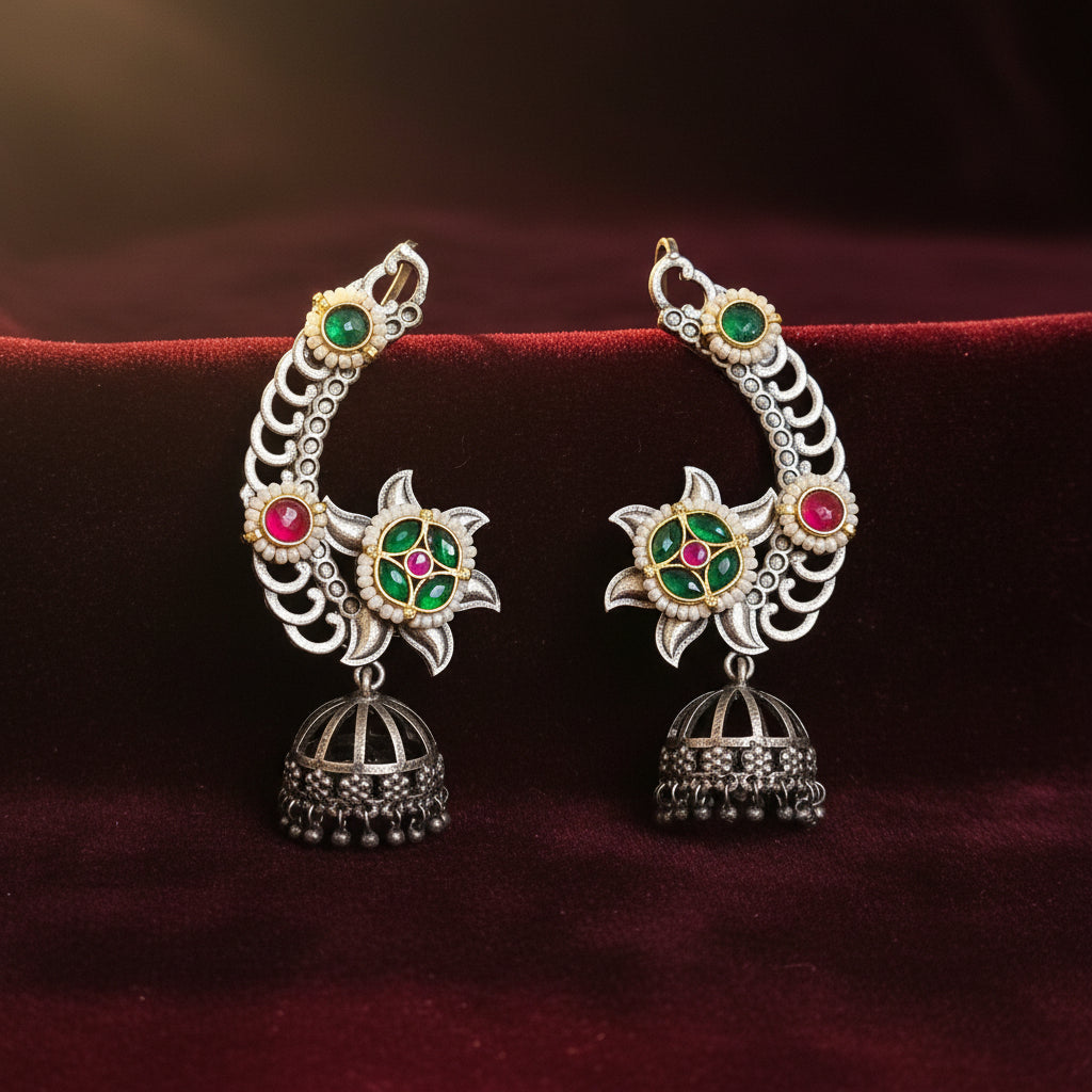 Decorative earrings with gemstones on a wooden stand with pink flowers and a pink background